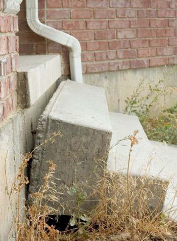 sinking outdoor concrete steps showing cracking and soil washout in Cumberland