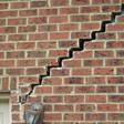 stair step cracking reaching from a window along the foundation wall in Orleans