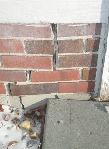 Severe street creep damage to a garage wall outside a Bourget home