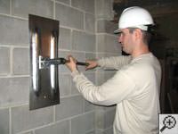 Attempting to straighten a bowed foundation wall by straightening a wall anchor system in a Vanier home.