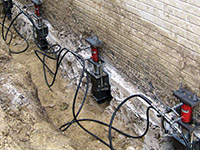 Using foundation push piers to lift a foundation during a repair in Renfrew.