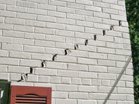 Stair-step cracks showing in a home foundation in Navah